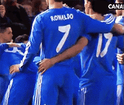 a group of soccer players are hugging and one of them has the number 7 on his shirt