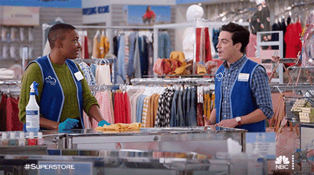 a man and a woman are standing in a clothing store talking