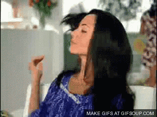 a woman is sitting on a couch with her eyes closed and a make gifs at gifsoup.com link