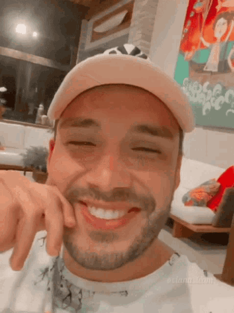 a man with a beard wearing a hat is smiling