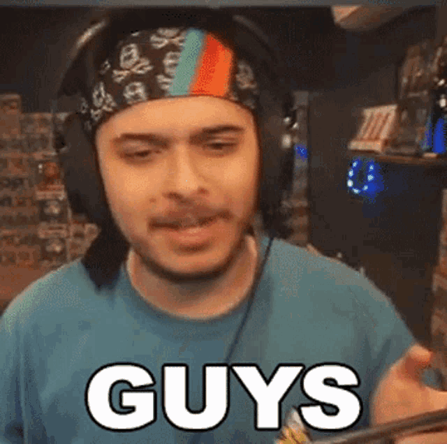 a man wearing headphones and a headband is making a funny face and saying guys .