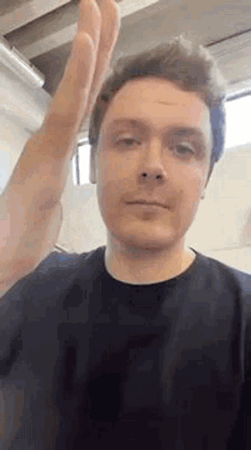 a man in a black t-shirt is giving a high five .