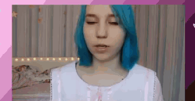 a girl with blue hair is wearing a white shirt and a pink bow .