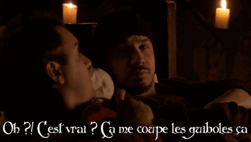 two men are talking in a dark room with candles in the background and the words oh cest vrai ca me coupe les guiboles ca