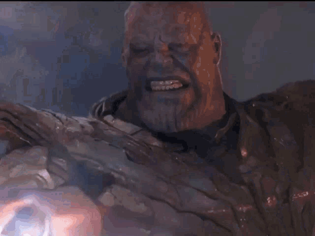 a man with purple hair and a beard is holding a rock in his hand .