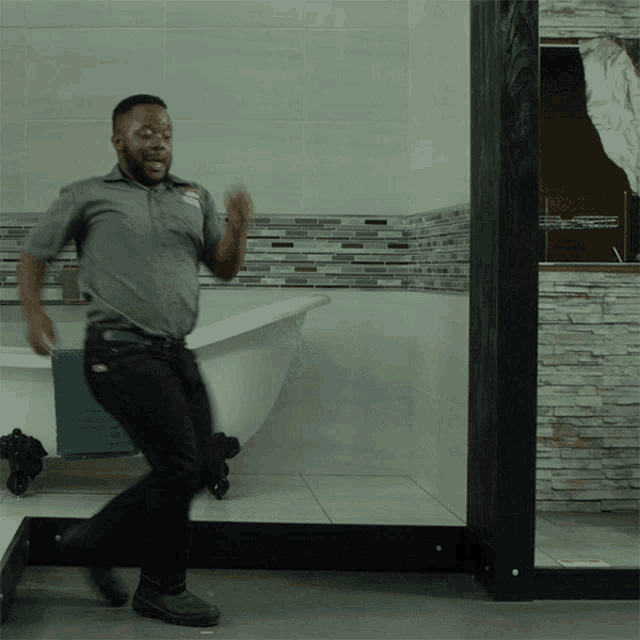 a man dancing in a bathroom with a bathtub