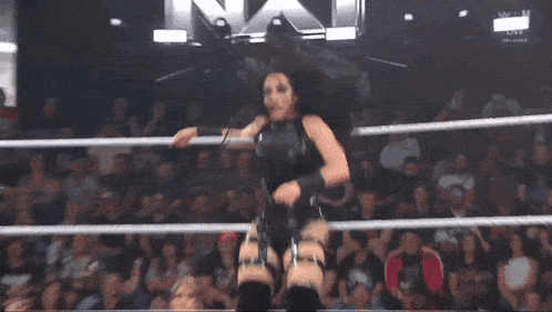 a woman in a bikini is in a wrestling ring with the letters n on the screen