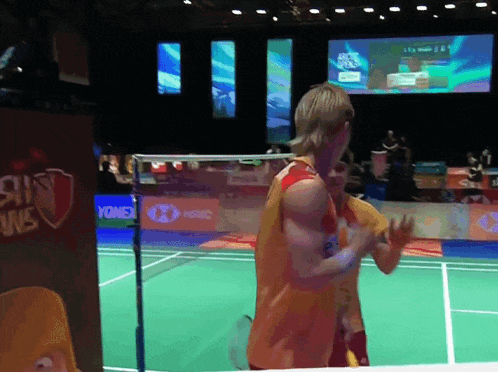 a badminton game is being played in front of a yonex sign