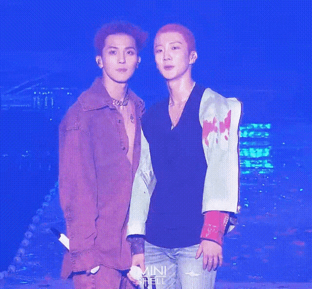 two young men are standing next to each other on a stage .