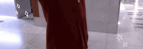a woman in a red dress is standing in a hallway with white stars on the floor