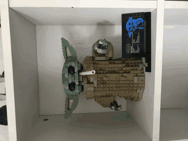 a lego model of the child sits on top of a white shelf