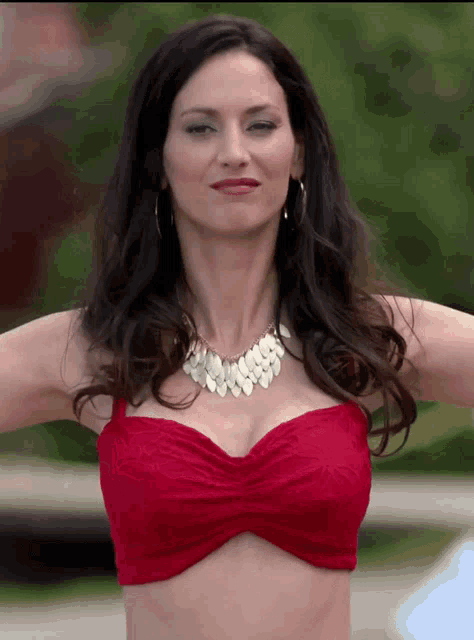 a woman wearing a red bikini top and a necklace