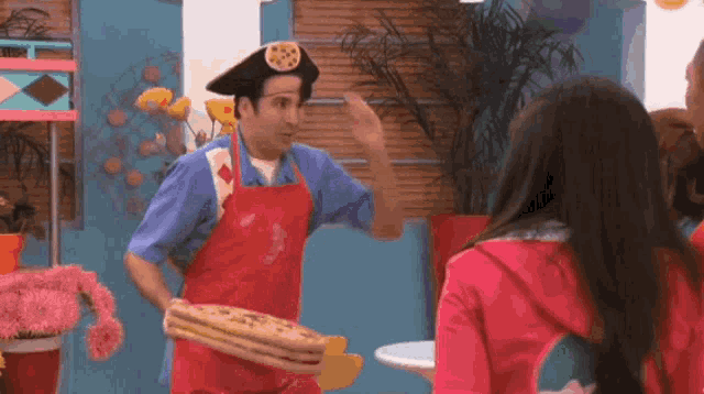 a man in a pirate hat is holding a stack of pizza