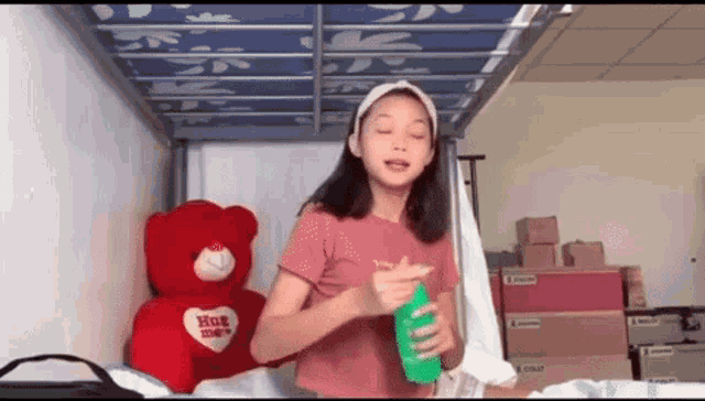 a girl is standing in front of a teddy bear that says hug me on it