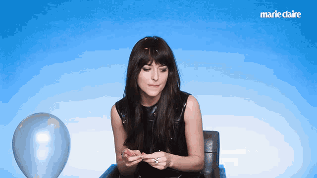a woman is sitting in front of a marie claire ad