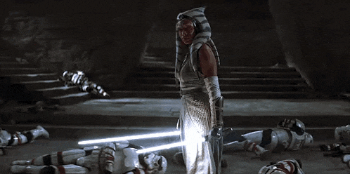 a woman is holding a light saber in front of a group of clone trooper soldiers .