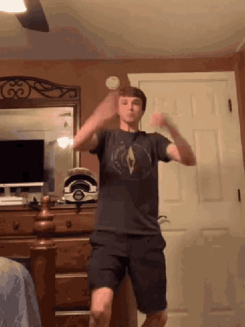 a young man wearing a compass shirt is dancing