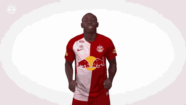 a man is wearing a red and white jersey with a red bull on it