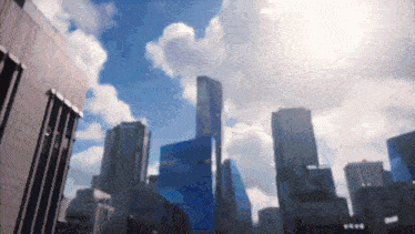 a city skyline with a blue sky and white clouds in the background