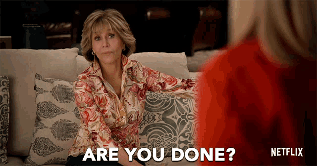 a woman sitting on a couch with the words " are you done " written below her