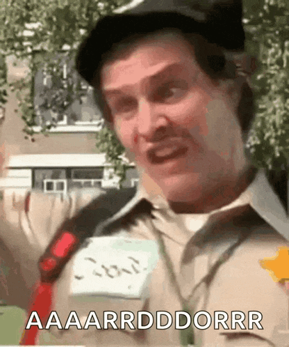 a man wearing a hat and a name tag says aaaarrddddrrr
