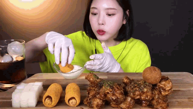 a woman wearing white gloves is eating fried chicken