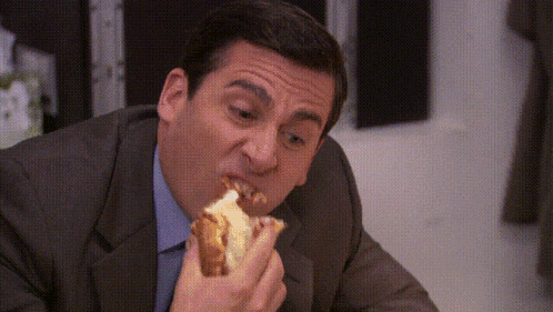 a man in a suit is eating a hot dog