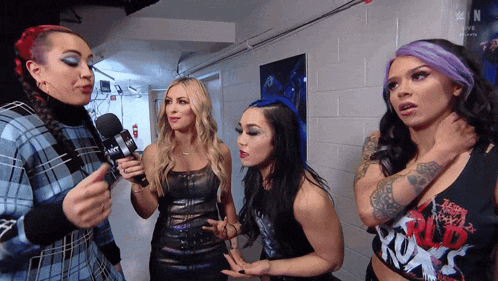 a group of women are standing next to each other and one of them is wearing a shirt that says world wrestling
