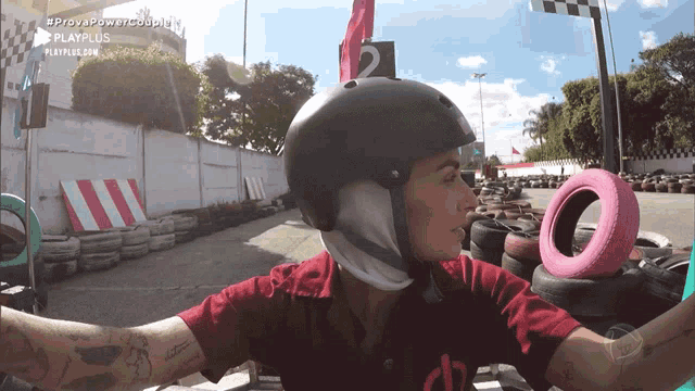 a woman wearing a helmet and a red shirt is holding a pink tire