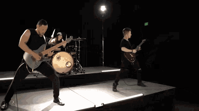 a man playing a guitar in front of a drum set that says yamaha on it