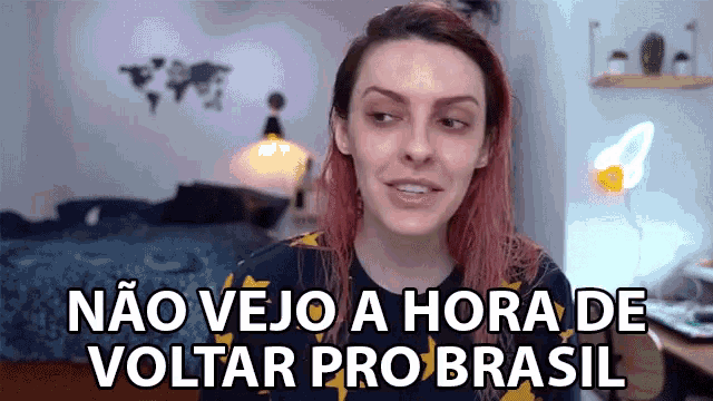 a woman with red hair is wearing a black shirt that says nao vejo a hora de voltar pro brasil