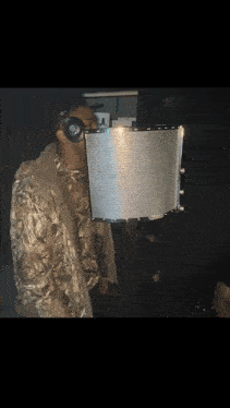 a man wearing a camo jacket is standing in front of a microphone