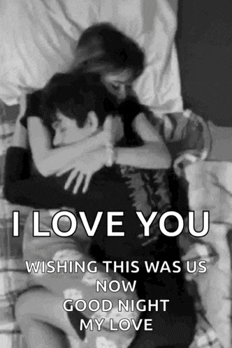 a black and white photo of a man and woman hugging each other on a bed .