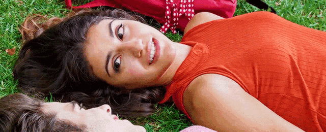 a man and a woman are laying in the grass
