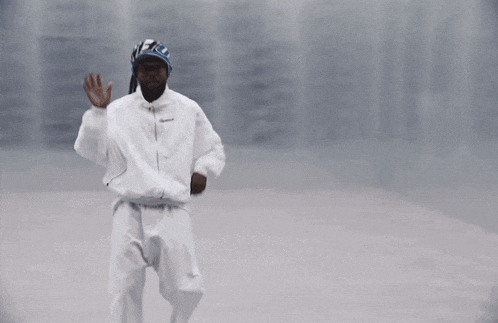 a man in a white jacket and pants is dancing
