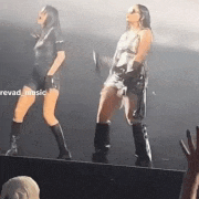 two women are dancing on a stage in front of a crowd with the words revad music written on the bottom