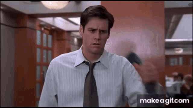 a man in a suit and tie is standing in a hallway .