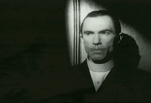 a black and white photo of a man in a suit and collared shirt .