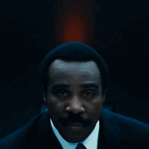 a man in a suit and tie has a blue lanyard around his neck that says ' google ' on it