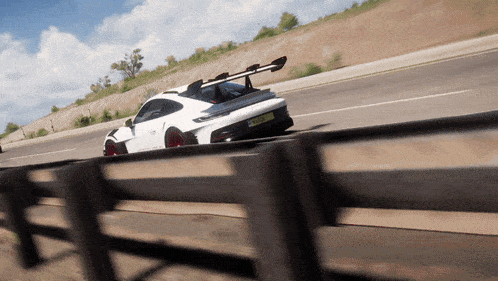 a white sports car is driving down a road with a license plate that says lc - rc - rc