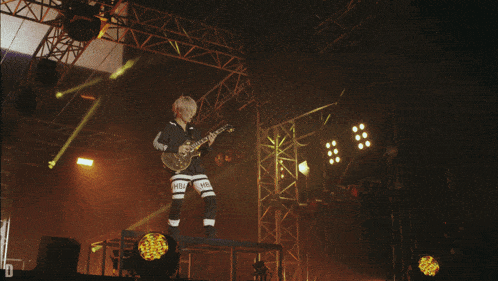 a person playing a guitar with hba on their shorts