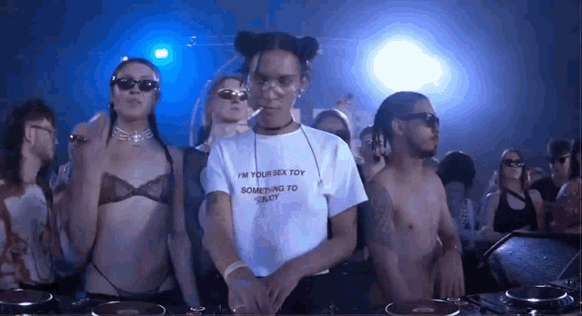 a man wearing a t-shirt that says " i 'm your sex toy " is smoking a cigarette