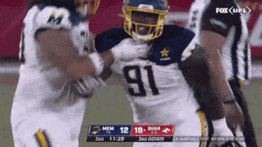 a football player wearing a number 91 jersey is being tackled by another player