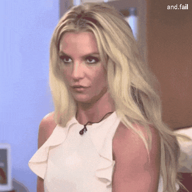a woman with long blonde hair is wearing a white top with ruffles on it