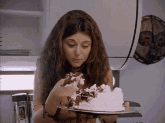 a woman is eating a cake with whipped cream on top