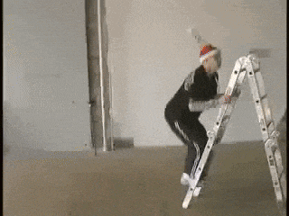 a man wearing a santa hat is climbing up a ladder