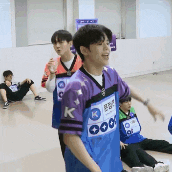 a man in a purple shirt with the letter k on the front