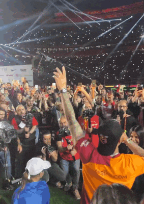 a crowd of people are gathered in a stadium and one of them is wearing a shirt that says ' istanbul '