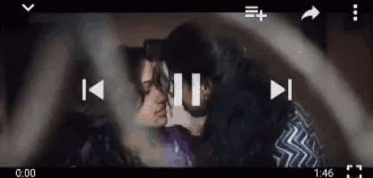 a man and a woman are kissing in a video being played on a phone .