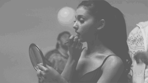 a woman is looking at herself in the mirror
